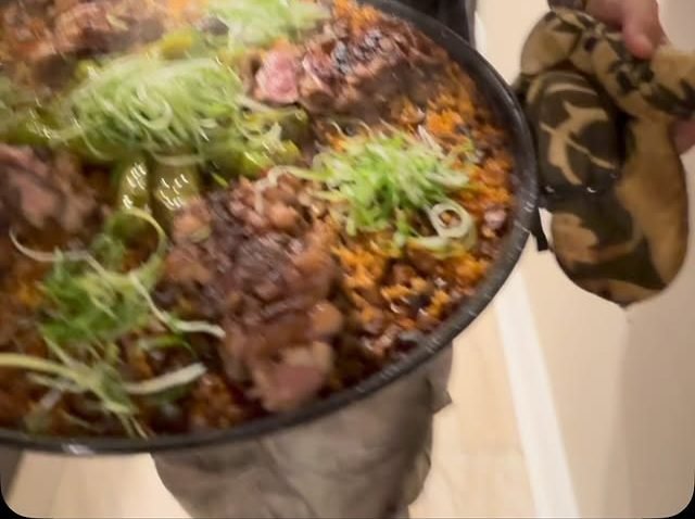 A large pan loaded with steak, poke and furikake rice topped with green onions